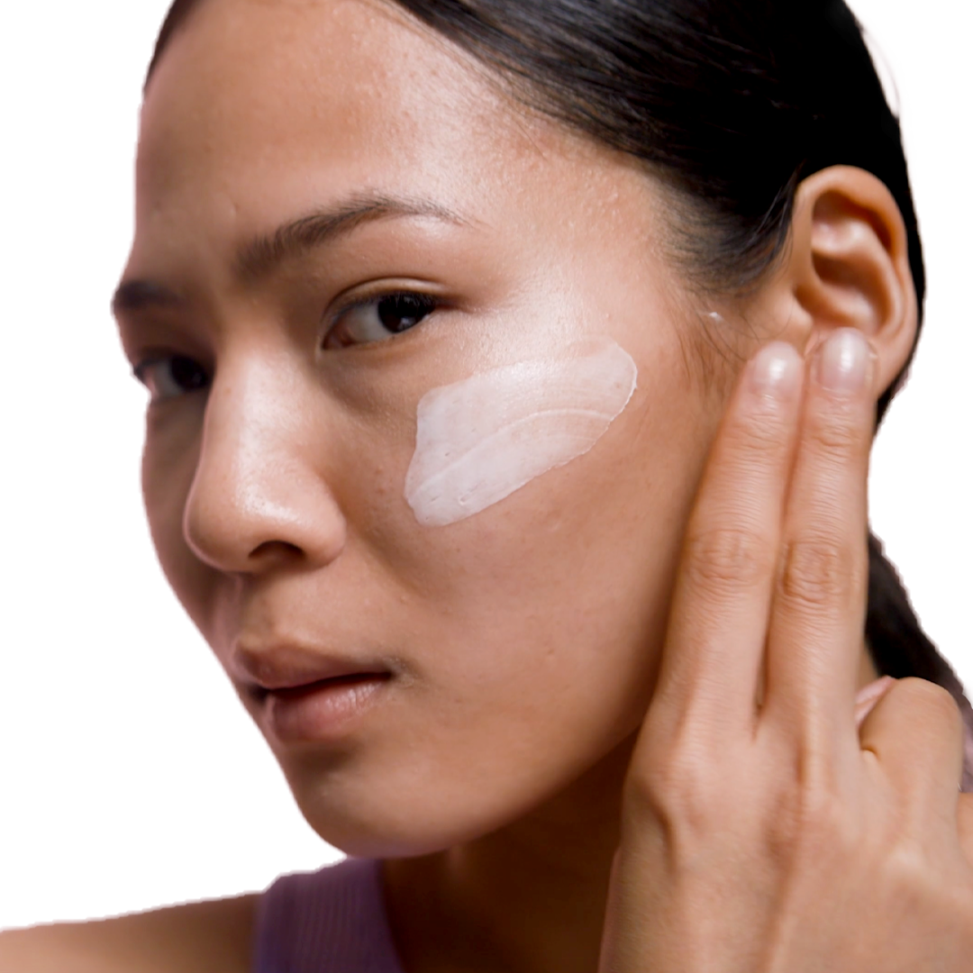 A woman using her ESK B Quenched moisturiser on her cheek. She swipes a good amount across her cheek to hydrate and moisturise her skin.