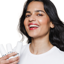 A woman holding her Hydroxy Overnight Mask. She uses the product overnight so that she can wake up with clear, glowy skin, That will work gentler than a peel.